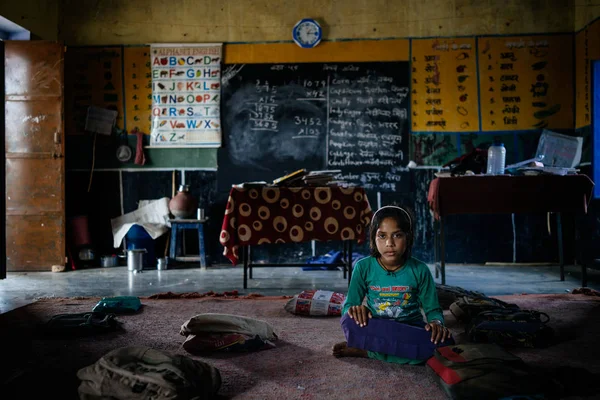 Little girl sitting on floor in classroom — Stock Photo, Image