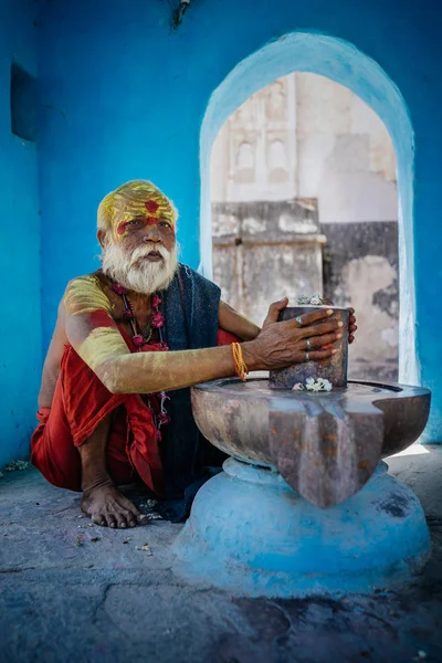 Indien homme accroupi et regarder la caméra — Photo