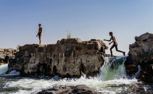 Ragazzi che saltano sulle rocce — Foto Stock