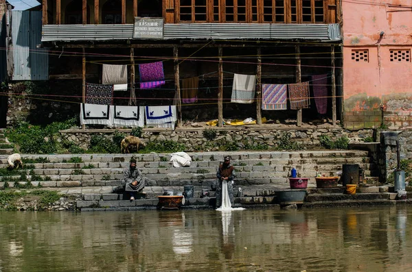 Män som tvättar kläder i floden — Stockfoto