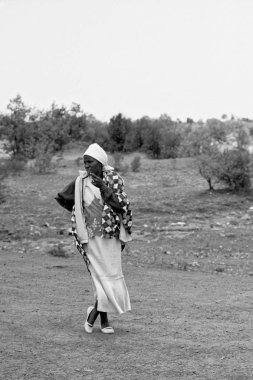 African woman walking on field clipart