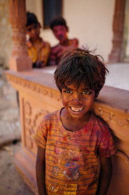 Çocuk kameraya bakarak holi boya