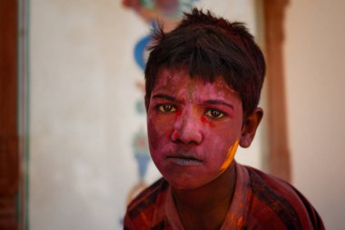 Çocuk kameraya bakarak holi boya