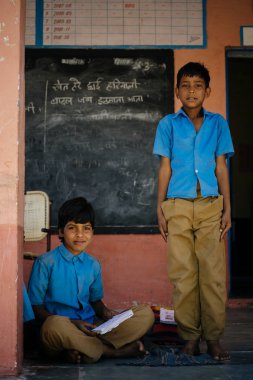 Okul çocukları üniformalı kameraya bakıyor