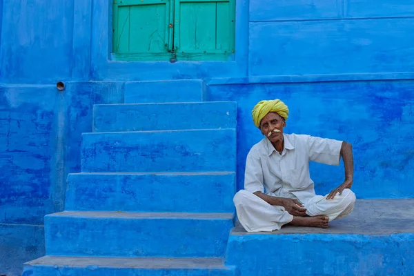 Hombre sentado en la superficie de piedra azul — Foto de Stock