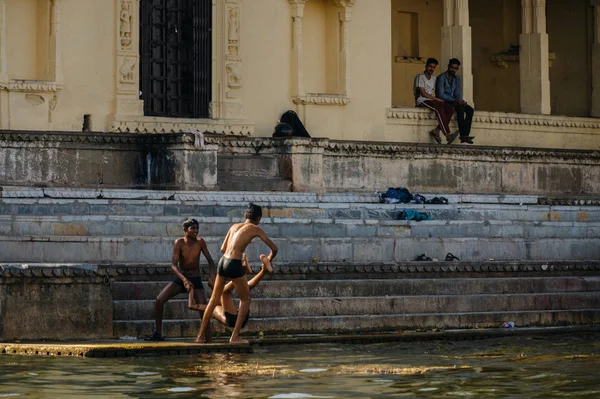 Мальчики бросают еще одного ребенка в воду — стоковое фото