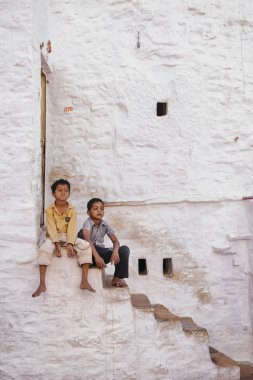 Taş merdivenlerde oturan iki çocuk
