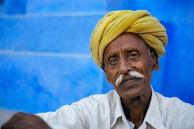 adam oturmuş ve kameraya bakıyor