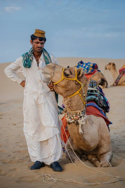 Uomo in piedi vicino a cammelli nel deserto — Foto Stock