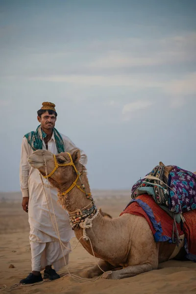 사막에서 낙 타 근처에 서 있는 남자 — 스톡 사진