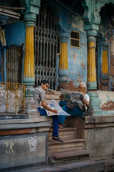 Two men reading newspapers