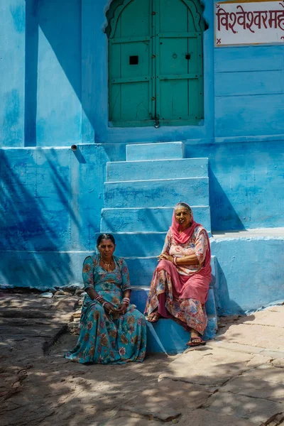 Dos mujeres sentadas en escaleras azules — Foto de Stock