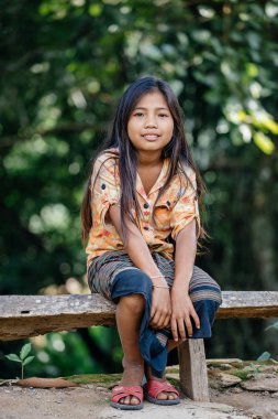 Kız gülümseyerek ve kameraya bakıyor