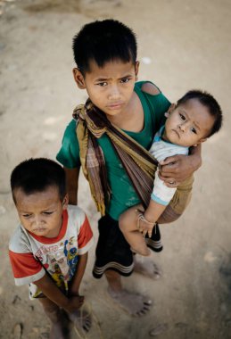 Üç çocuk kameraya bakıyor