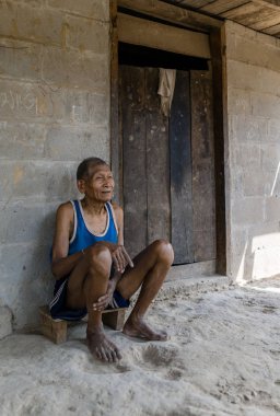 Tuğla bina önünde oturan adam