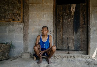 Tuğla bina önünde oturan adam