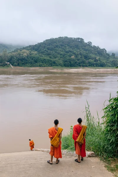 Mönche stehen am Ufer des Flusses — Stockfoto