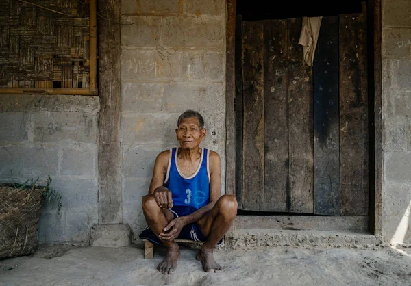 Tuğla bina önünde oturan adam