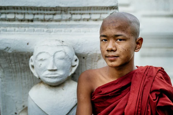Boeddhistische monnik permanent in de buurt van standbeeld — Stockfoto