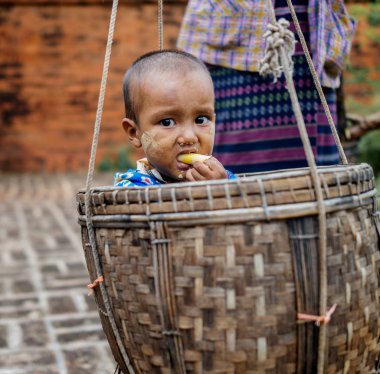 Kova içinde oturma ve yemek küçük çocuk 