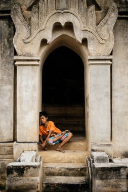 Bina açık basamaklarında oturan çocuk