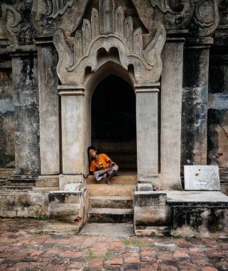 Bina açık basamaklarında oturan çocuk