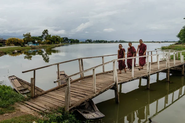 Drie monniken lopen op landelijke brug — Stockfoto