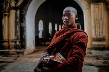 Ayakta ve kameraya bakarak Budist rahip