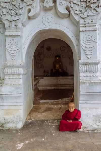 Pequeño monje sentado frente al templo — Foto de Stock