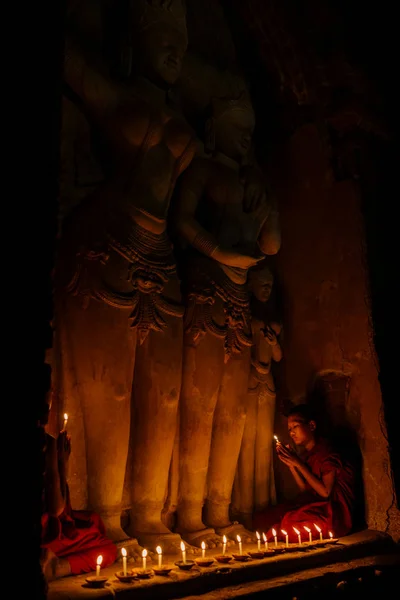 Monjes sentados y rezando con velas —  Fotos de Stock