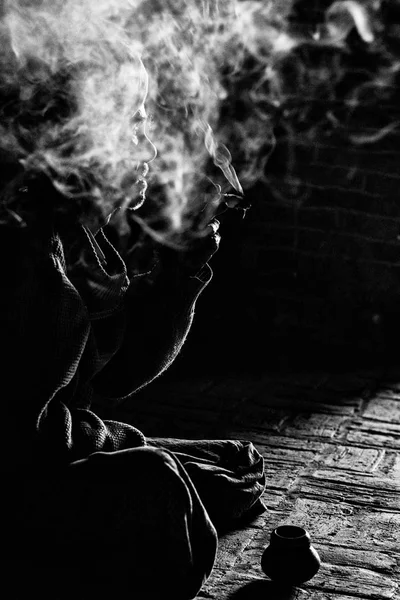 Hombre sentado en el suelo y fumando —  Fotos de Stock