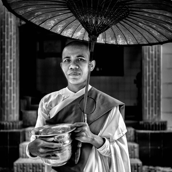 Buddhist monk standing with umbrella — Stock Photo, Image