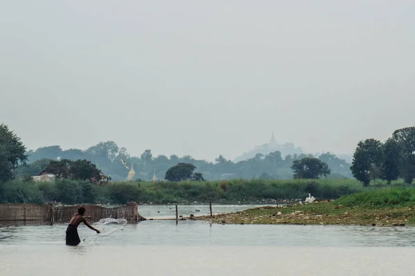 Mann steht im Fluss und fischt — Stockfoto