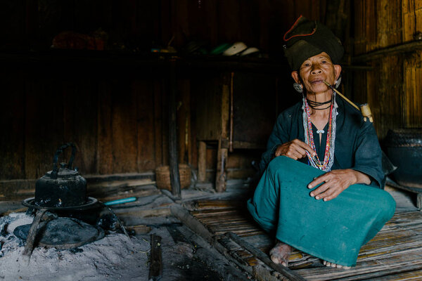 Старшая женщина курит большую трубку
