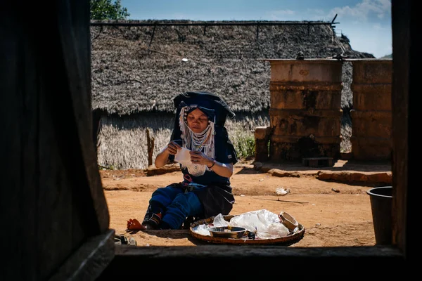 Donna in abbigliamento tradizionale seduta e cucina — Foto Stock