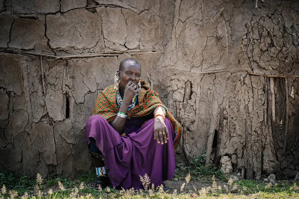 Žena z afrického kmene, posezení u chaty — Stock fotografie