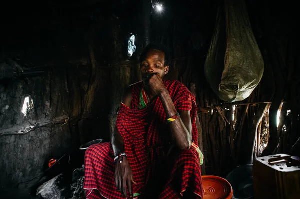 Uomo in abiti tradizionali seduto in capanna — Foto Stock