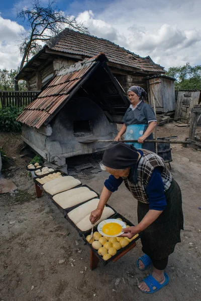 Donne anziane che cucinano il pane fuori — Foto Stock