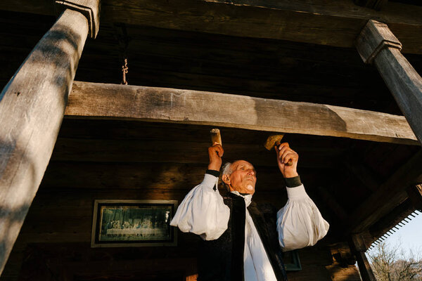 Man beating wood plank 