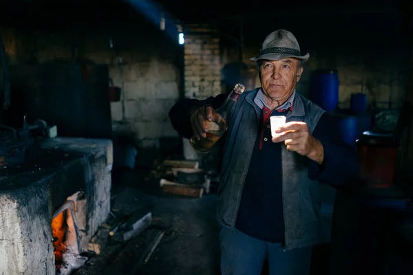 Hombre sosteniendo botella de alcohol y vaso de chupito — Foto de Stock