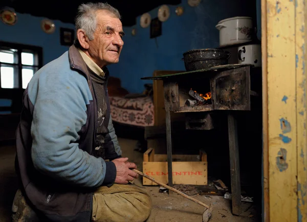 Uomo seduto in ginocchio in capanna — Foto Stock