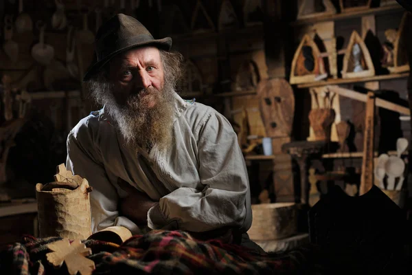 Karanlık oda içinde oturan şapkalı sakallı adam