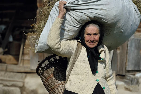 Donna che porta sacco di fieno — Foto Stock