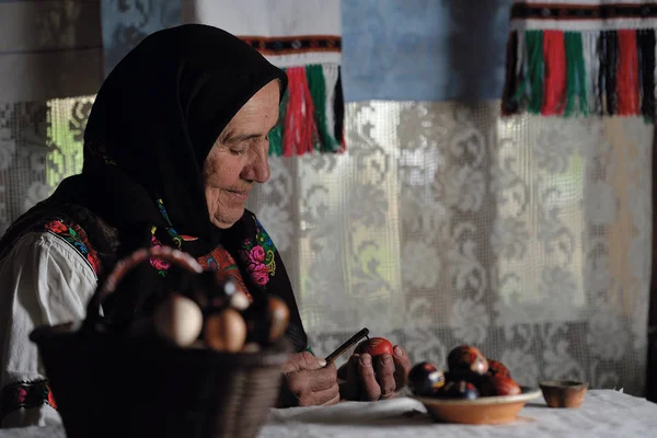 Yaşlı kadın Paskalya yumurta boyama
