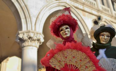 Karnavalda ayakta Venedik maskeli insanlar
