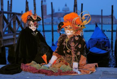 Karnavalda ayakta Venedik maskeli insanlar
