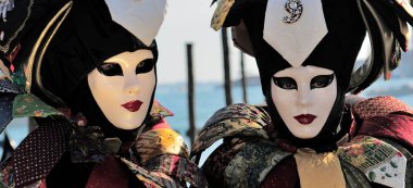 Karnavalda ayakta Venedik maskeli insanlar