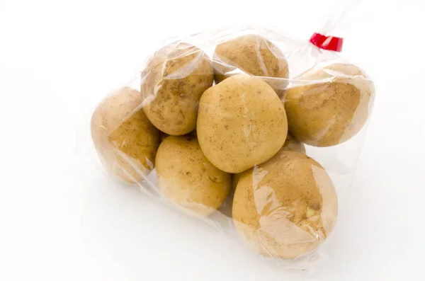 白い背景のビニール袋の中の新鮮なジャガイモ — ストック写真
