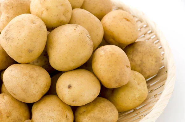 Patates, beyaz arka planda bambu eleği.