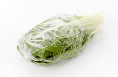 Beyaz arka planda plastik torba içinde taze yeşil İsviçre pazarı